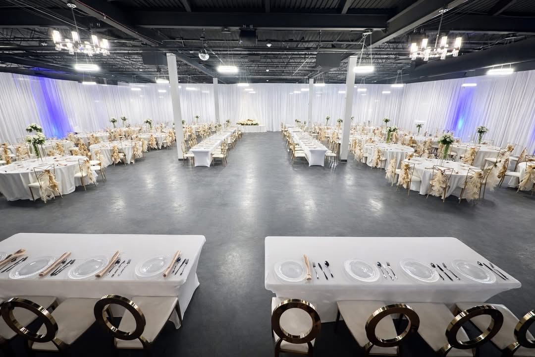 Crystal Venue dressed in white linens with gold chairs and crystal chandeliers